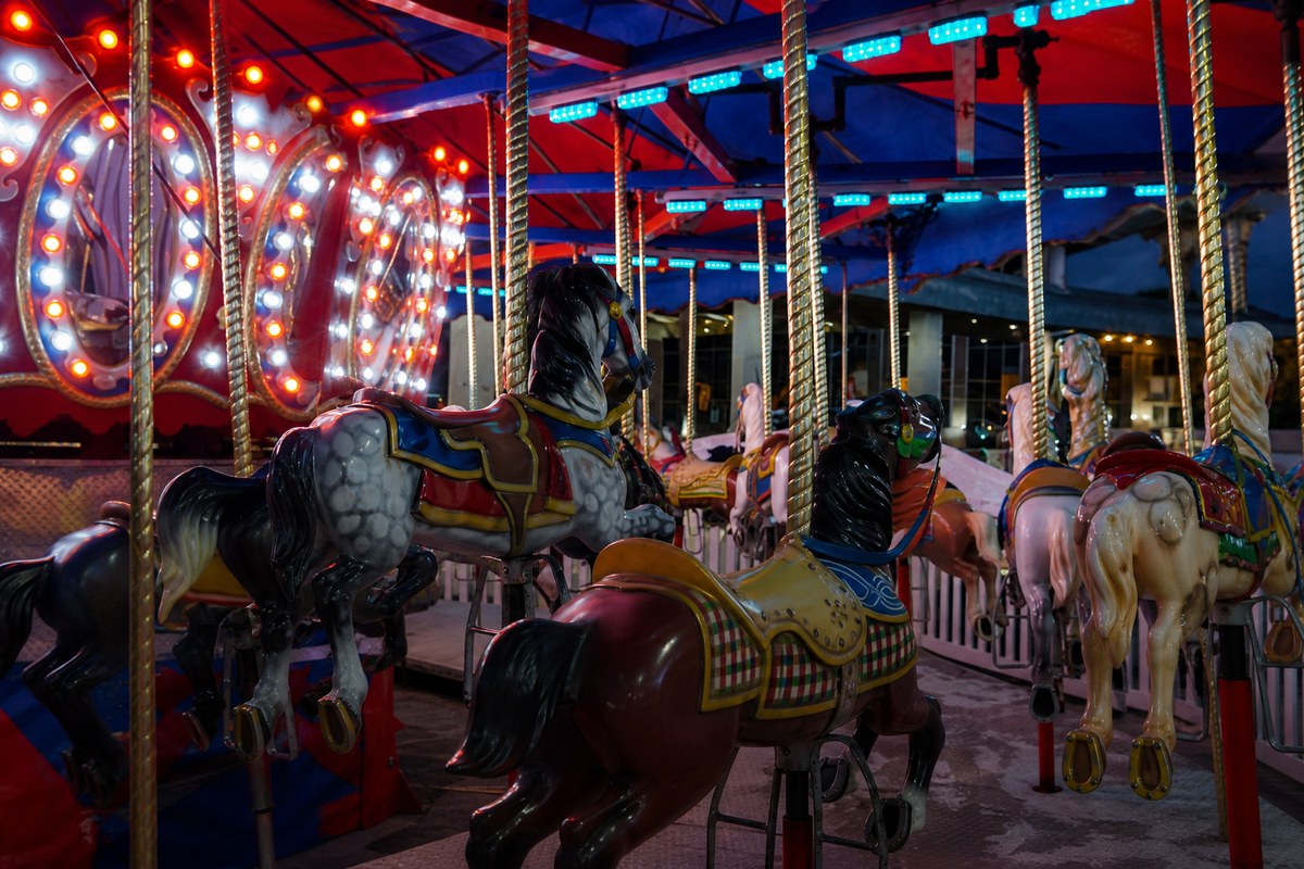 Illuminated carousel horses at blue hour